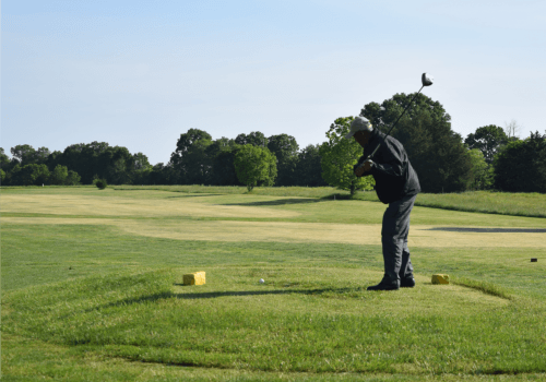 Man Teeing off at a Golf Course